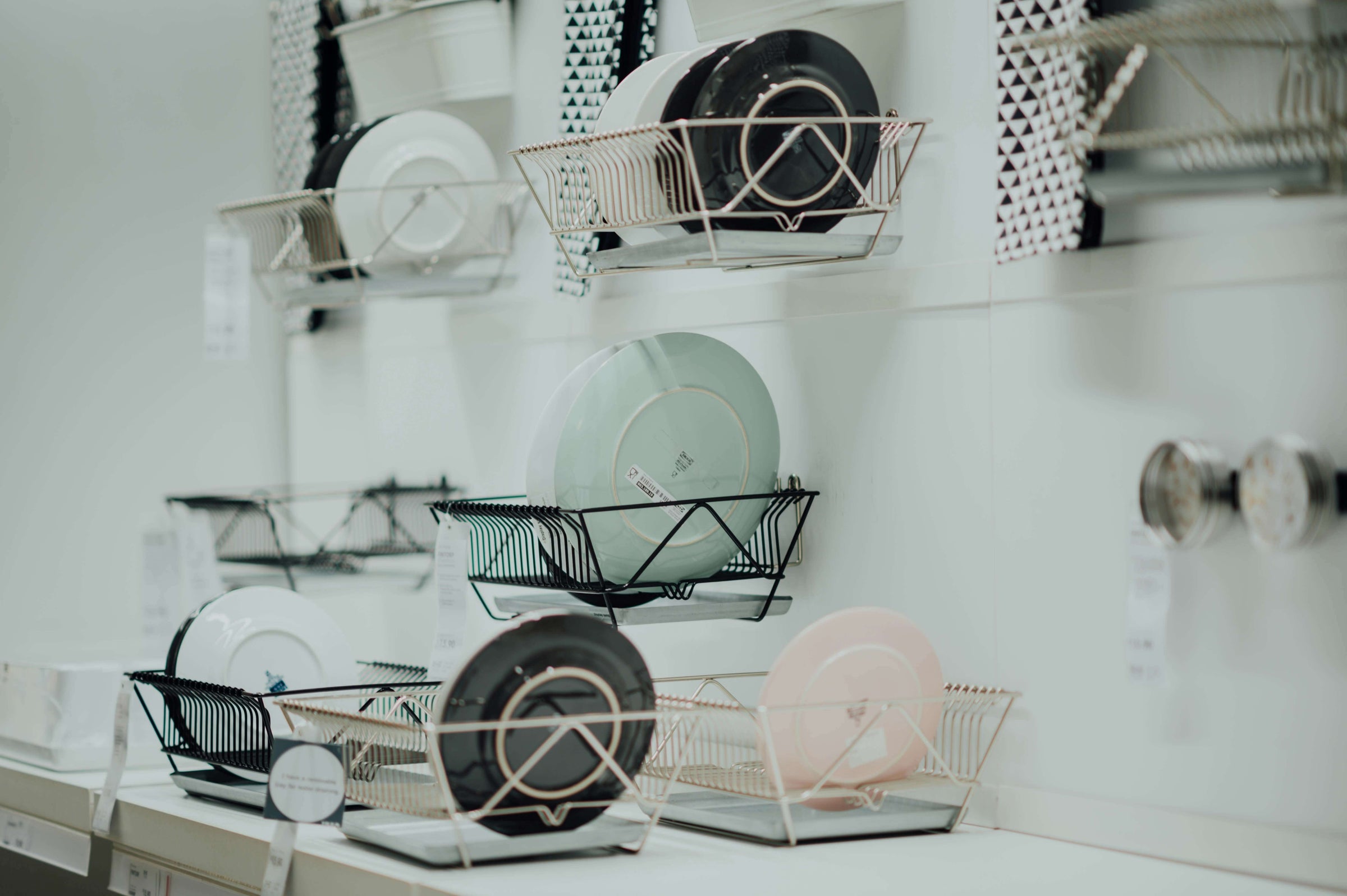 Modern dish racks on display in a kitchen store, showcasing affordable storage solutions for efficient kitchen organization.