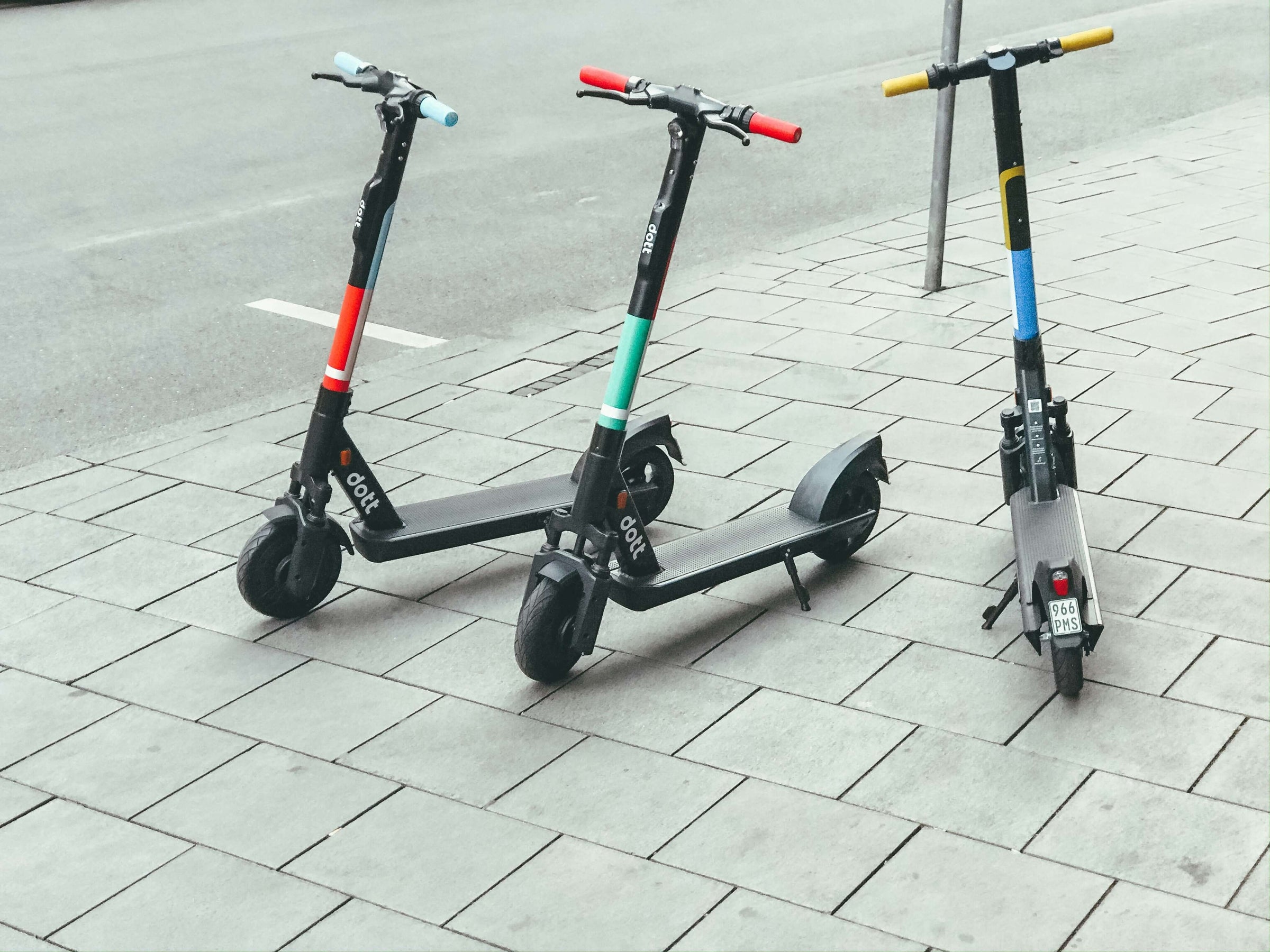 Three stylish electric scooters parked on a city sidewalk, showcasing affordable ride-on options for fun and adventure on a budget.