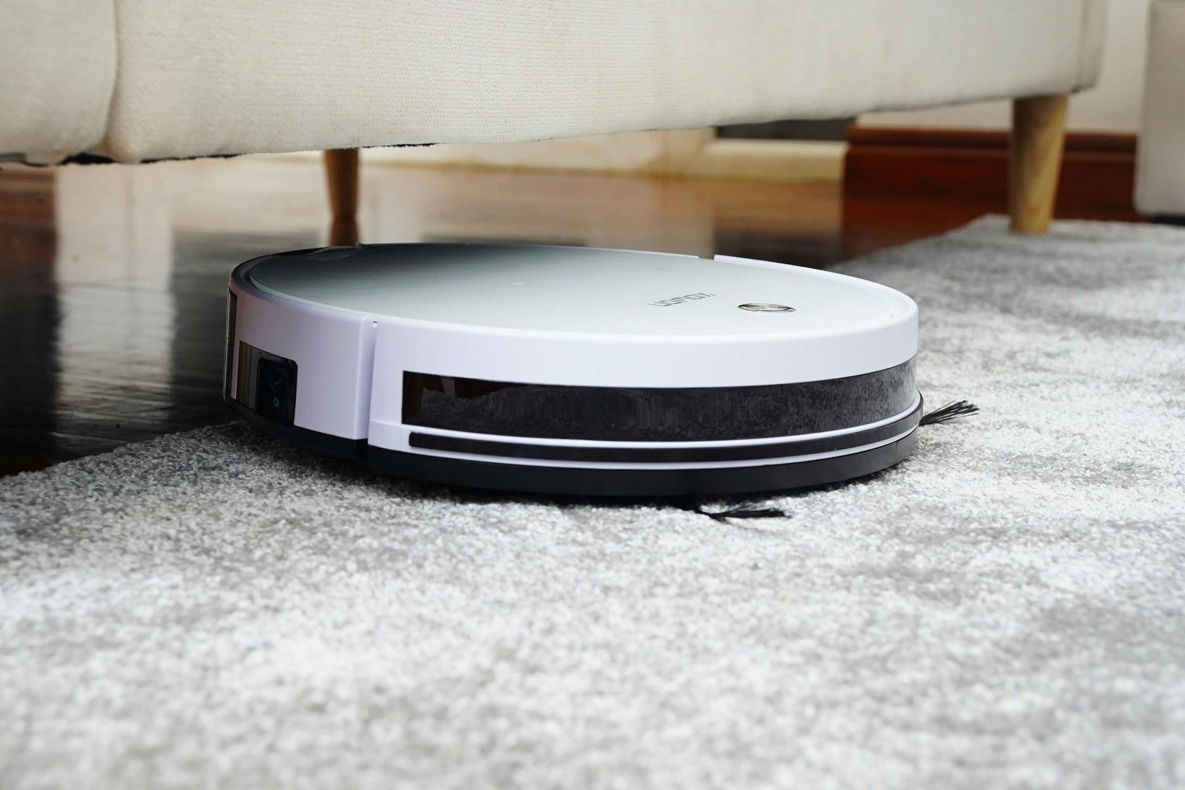 Affordable stylish robot vacuum cleaning a carpet, perfect for budget-conscious home cleaning solutions.