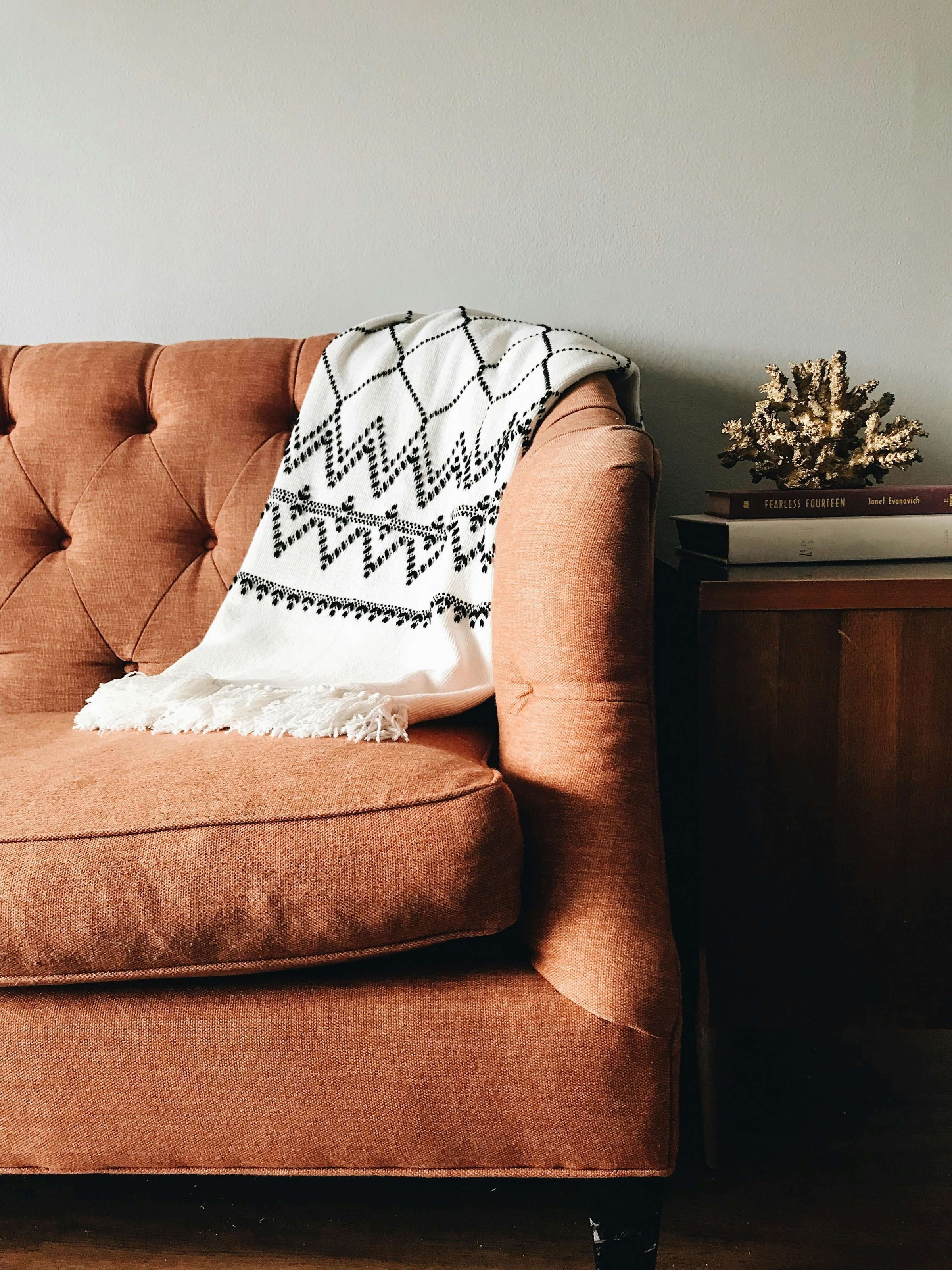 Stylish black and white throw on a cozy brown sofa, adding warmth and elegance to a living space.