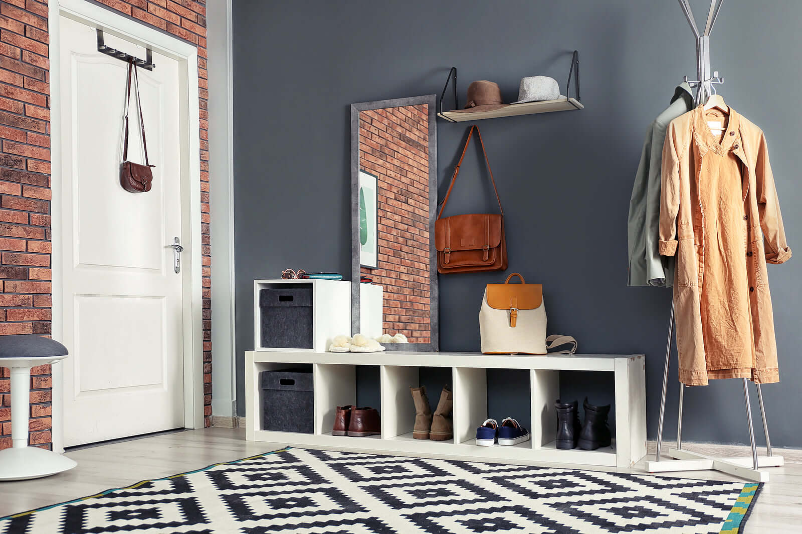 Affordable and stylish entryway with shoe and coat storage, featuring racks and cabinets for organized living on a budget.