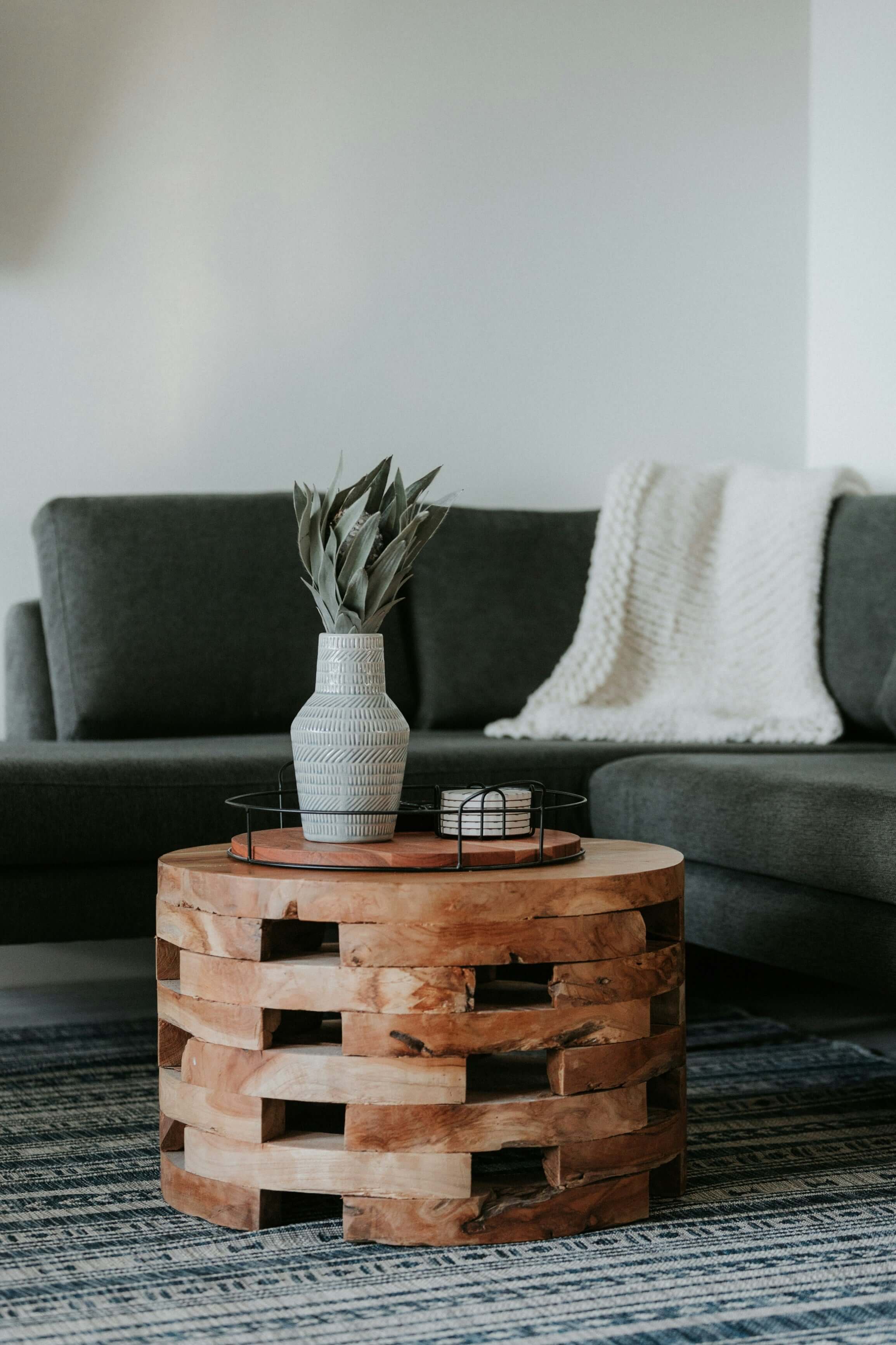 Stylish wooden coffee table with decor, enhancing a modern living room setting with affordable elegance on a budget.