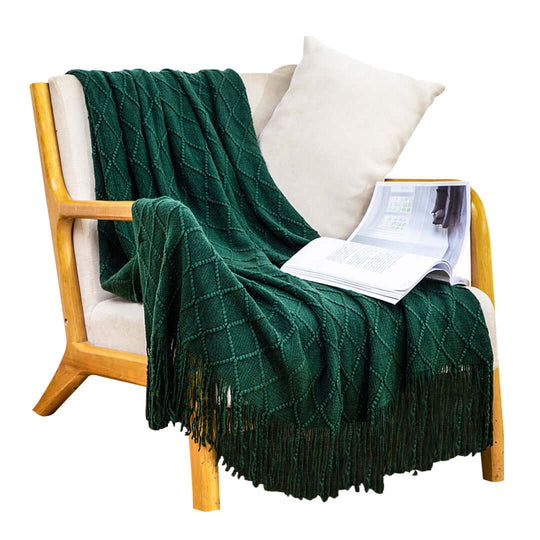 Affordable quality homewares - green knit blanket draped on a wooden chair with a book. Cozy and stylish value furniture.