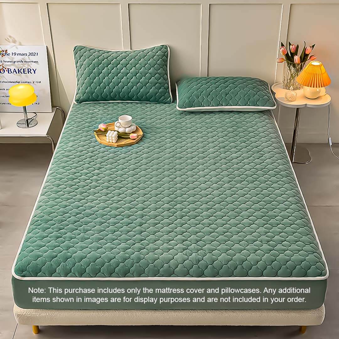 Affordable quality mattress with green quilted cover and matching pillows on a neatly arranged bedroom display.