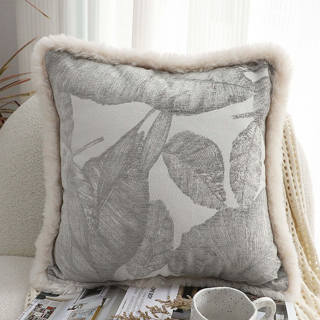 Affordable quality homewares - grey leaf-patterned throw pillow with light fur trim, offering value furniture decor.