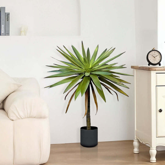 Indoor affordable homewares featuring a quality artificial potted plant placed near a value furniture sofa and side table.