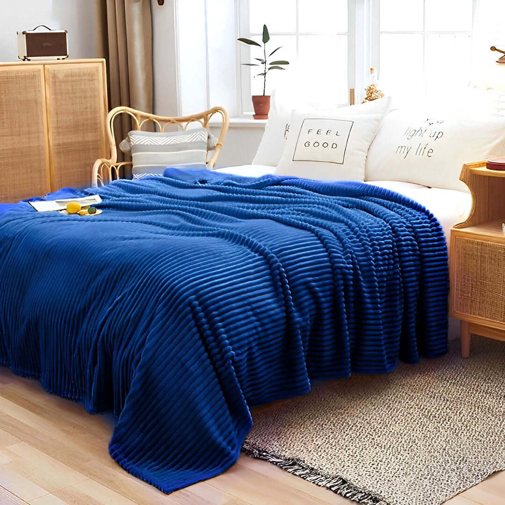 Cozy bedroom with blue ribbed blanket, affordable homewares, quality value furniture, and feel-good pillows on a well-made bed.