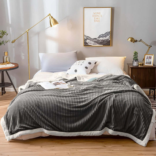 Affordable quality homewares including a cozy gray blanket on a stylish bed showcasing value furniture in a modern bedroom setup.