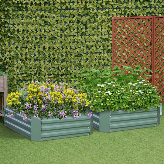 Raised garden beds with blooming flowers and greenery, set against a lush ivy-covered wall and a red lattice fence in a backyard.