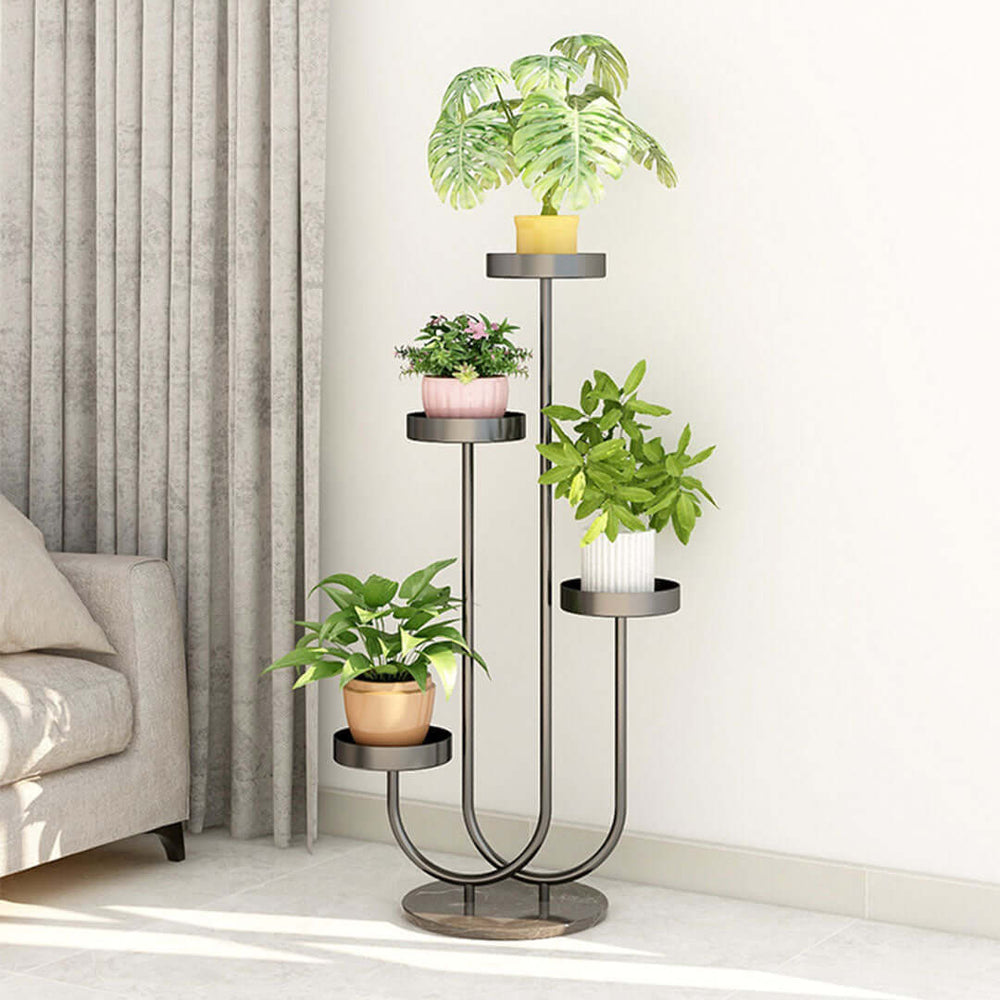 Modern indoor plant stand holding four potted plants, placed beside a gray curtain and neighboring a sofa, showcasing affordable homewares.