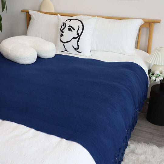 Modern bedroom with navy blue blanket, artistic pillow, and cozy decor showcasing affordable, quality homewares and value furniture.