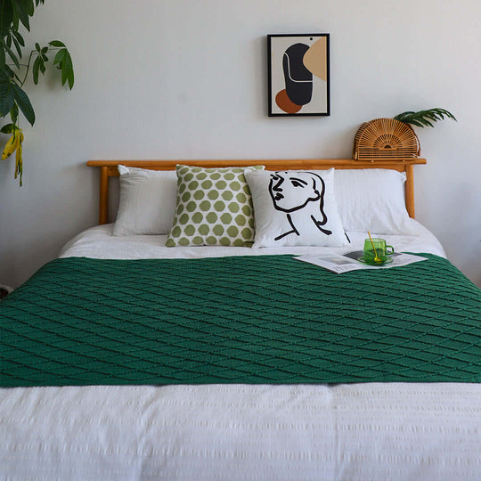 Affordable and stylish bedroom setup with quality furniture and homewares featuring green throw blanket and modern wall art.