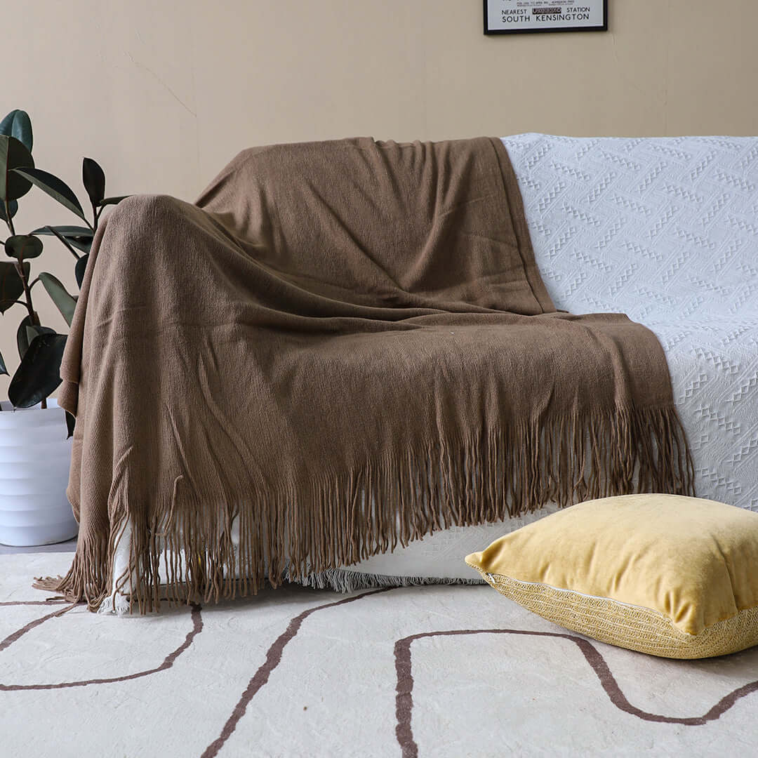 Cozy living room with affordable quality homewares including a fringed brown throw and yellow cushion on value furniture.