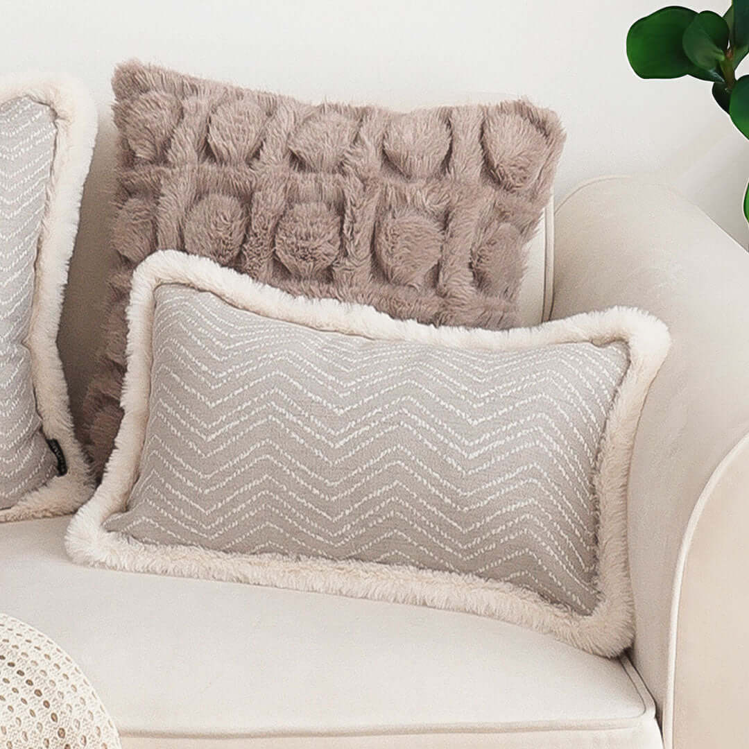 Affordable homewares - quality and value furniture featuring stylish beige and gray cozy pillows on a cream sofa.