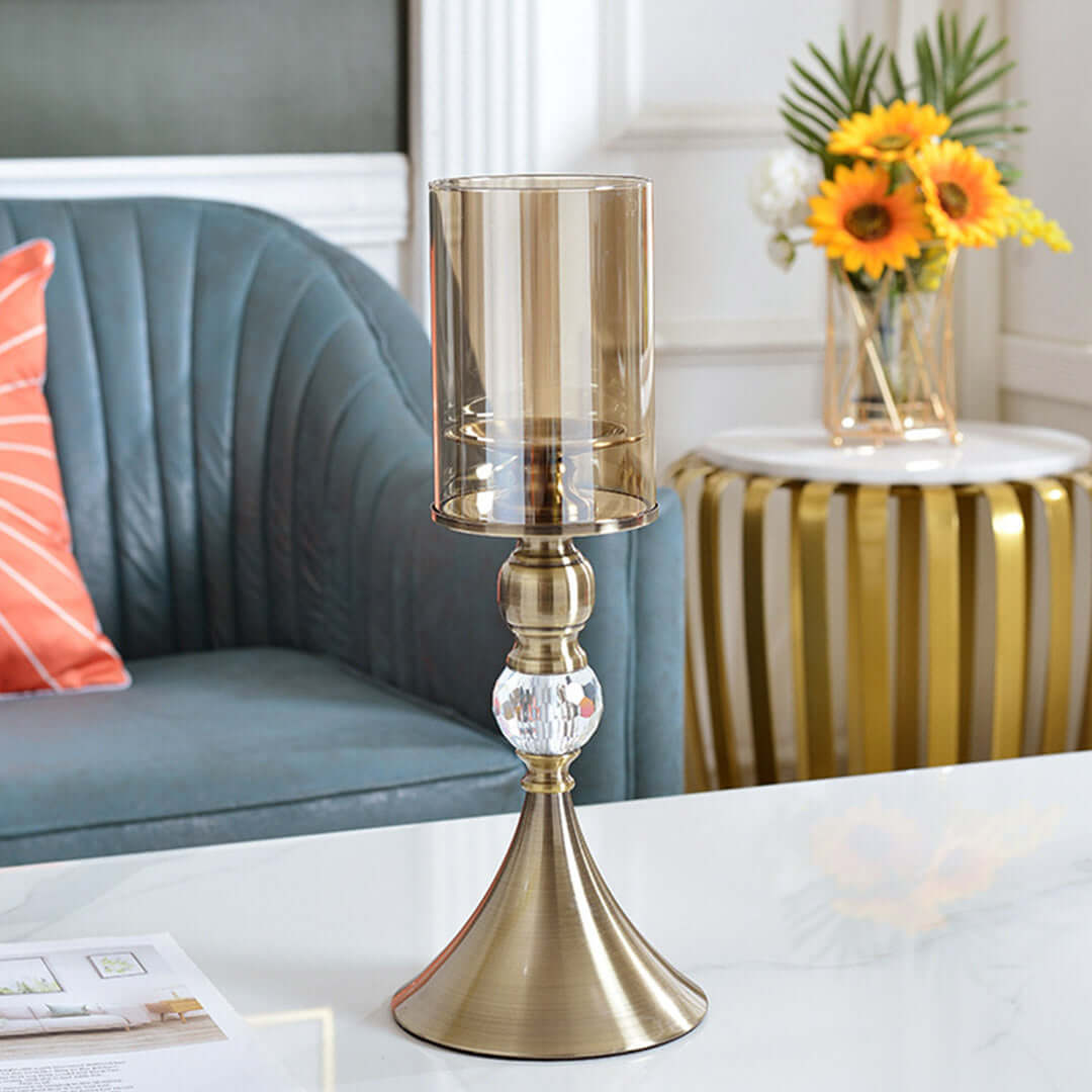 Stylish metallic candle holder on white table, with blue sofa and decorative items in the background, showcasing affordable, quality homewares.