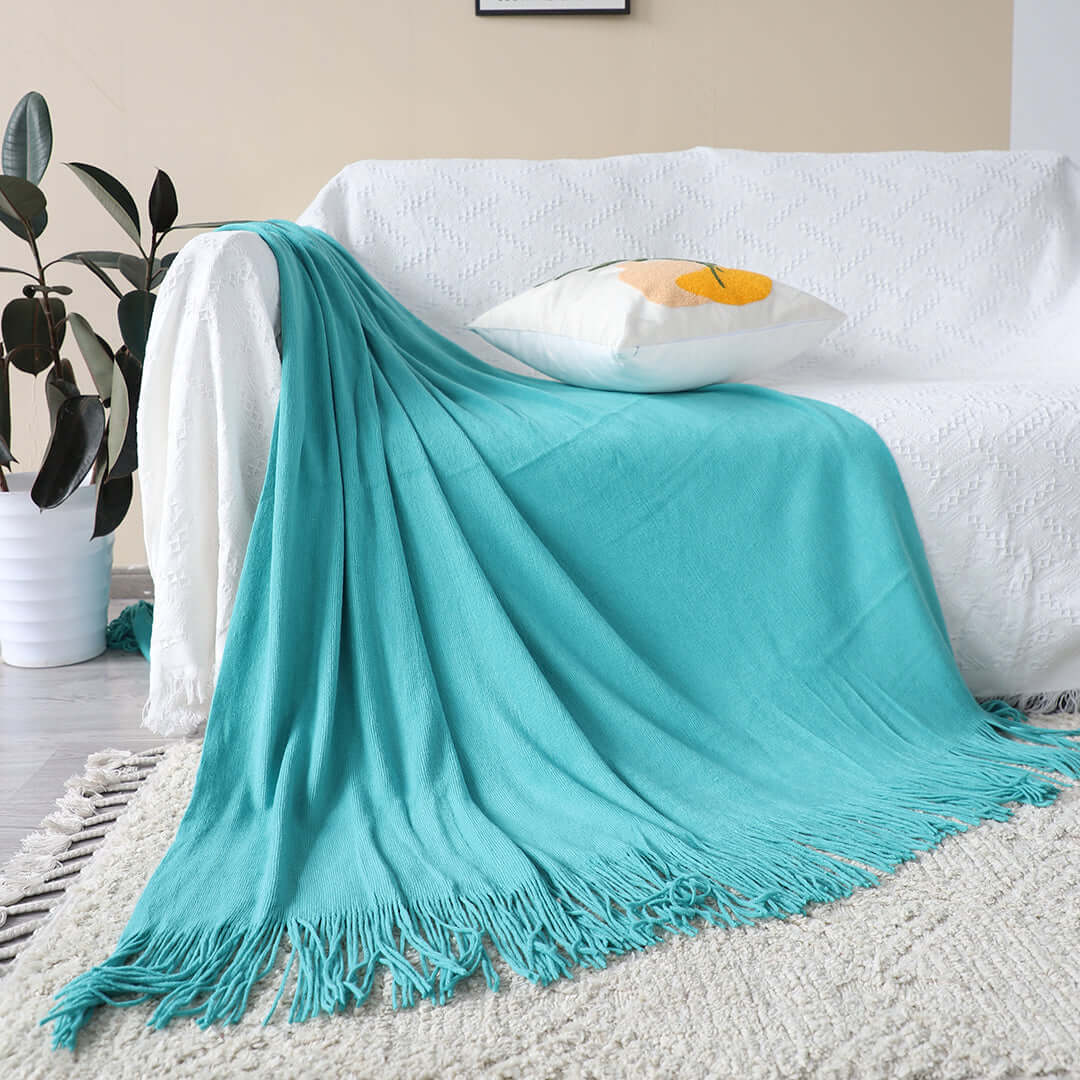 Affordable quality homewares - Turquoise throw blanket with tassels draped over white sofa for a cozy, value furniture look