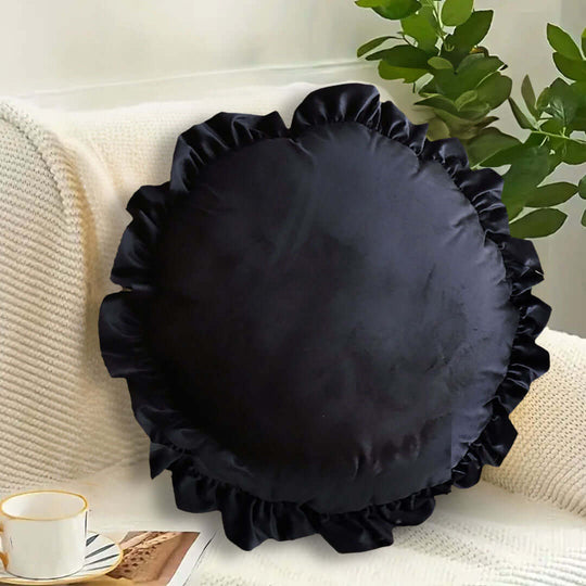 Affordable quality black ruffled cushion on a cream sofa with a cup of coffee, showcasing stylish homewares and value furniture.