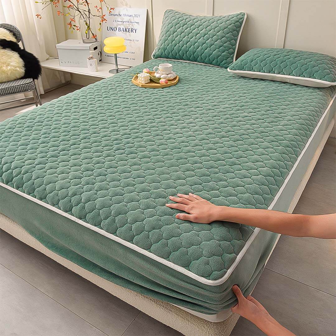 High-quality affordable green quilted mattress cover with matching pillows, showcasing value furniture homewares in a cozy bedroom setting.