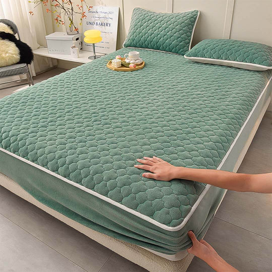 High-quality affordable green quilted mattress cover with matching pillows, showcasing value furniture homewares in a cozy bedroom setting.