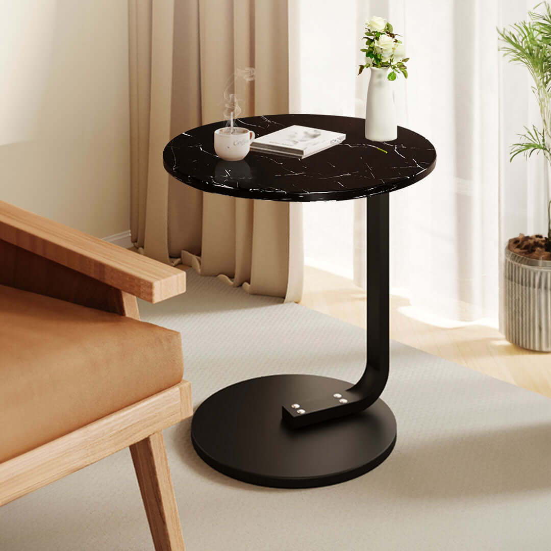 Affordable quality homeware - elegant black round side table beside a wooden chair in a cozy living room setting