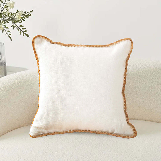 Affordable quality white throw pillow with decorative edging on a cozy chair, perfect value furniture and homewares.