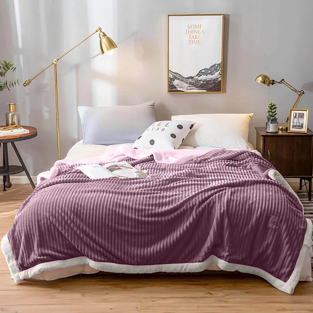 Cozy bedroom with affordable quality homewares, featuring a plush purple blanket, decorative pillows, and stylish value furniture.