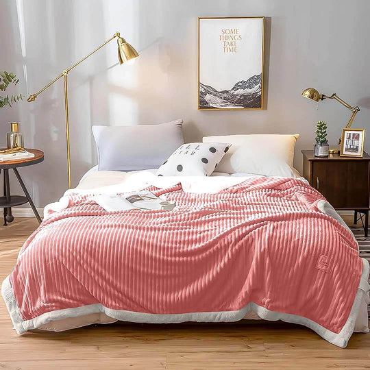 Affordable homewares: Cozy bedroom with quality, value furniture and a stylish pink blanket on a neatly made bed.