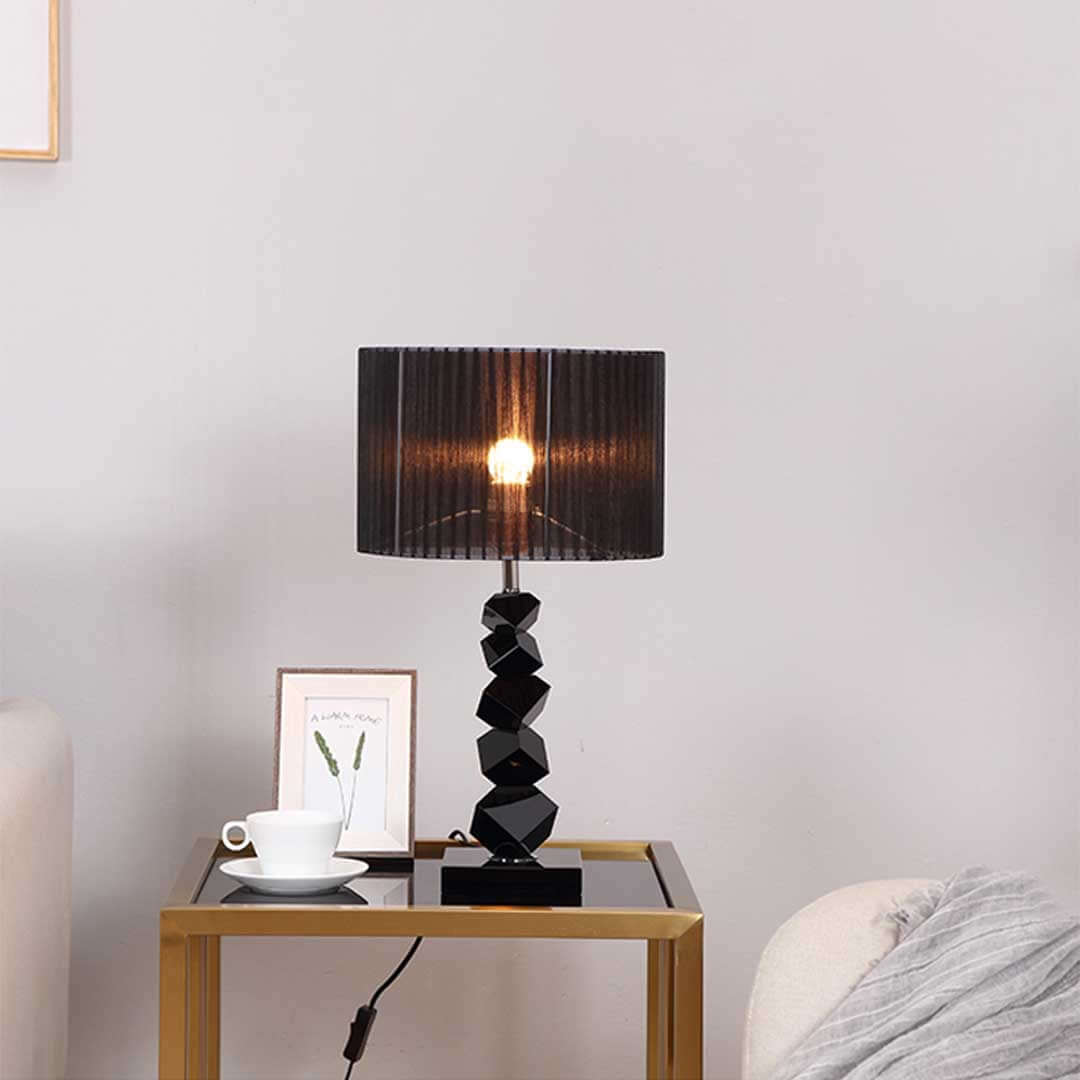 Modern black table lamp with geometric design on a stylish table next to a cup and framed artwork, showcasing affordable homewares and quality value furniture.