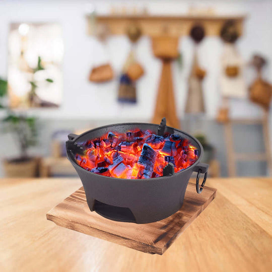 Affordable quality homewares: Black cast-iron fire pot with red and blue glowing embers, adding value to your furniture and decor.