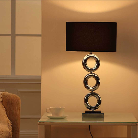 Modern black and chrome table lamp in cozy living room, highlighting affordable quality homewares and value furniture.