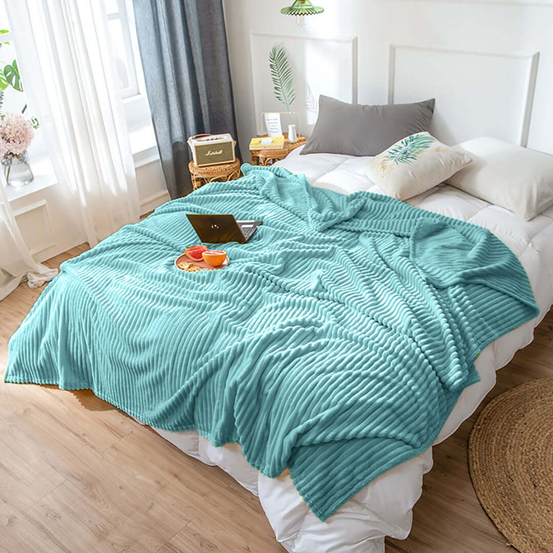 Comfortable teal blanket on a bed in a cozy, stylish bedroom showcasing affordable and quality homewares and value furniture.