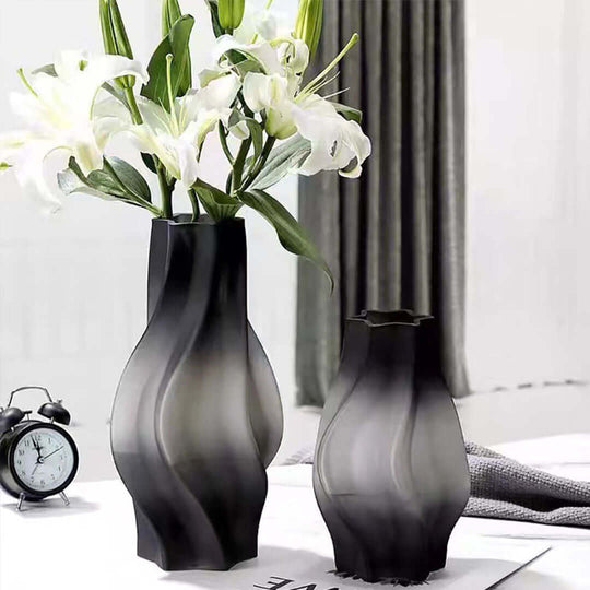 Stylish black and grey vases with white lilies placed on a table, showcasing affordable and quality homewares and value furniture.