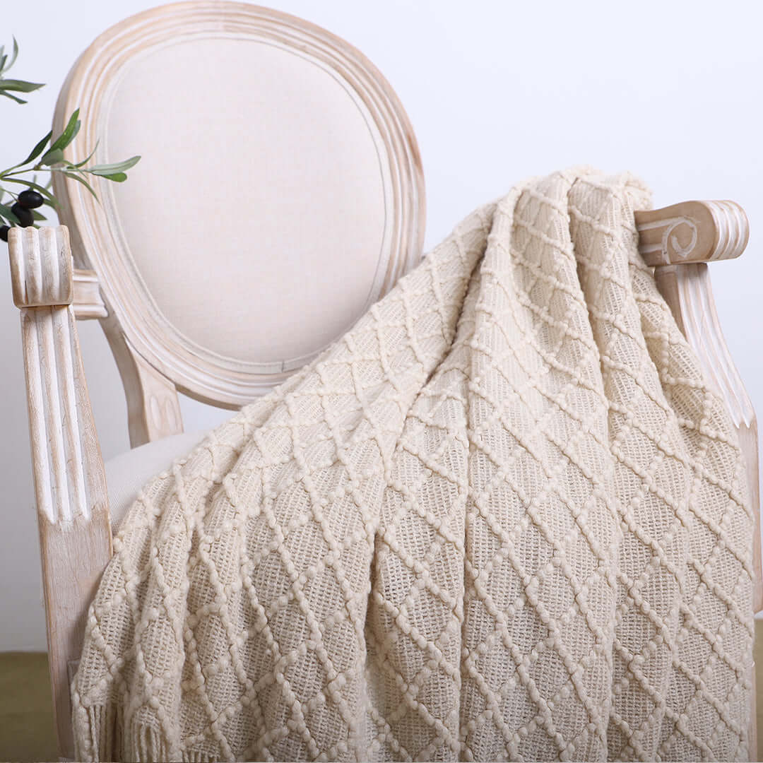 Beige knitted throw draped over a white wooden chair, showcasing affordable, quality homewares and value furniture.