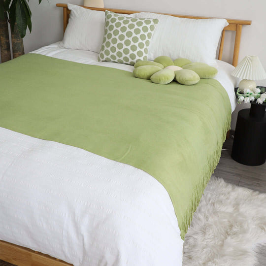 Affordable quality homewares featuring a stylish bed setup with green and white bedding, showcasing value furniture and cozy decor.