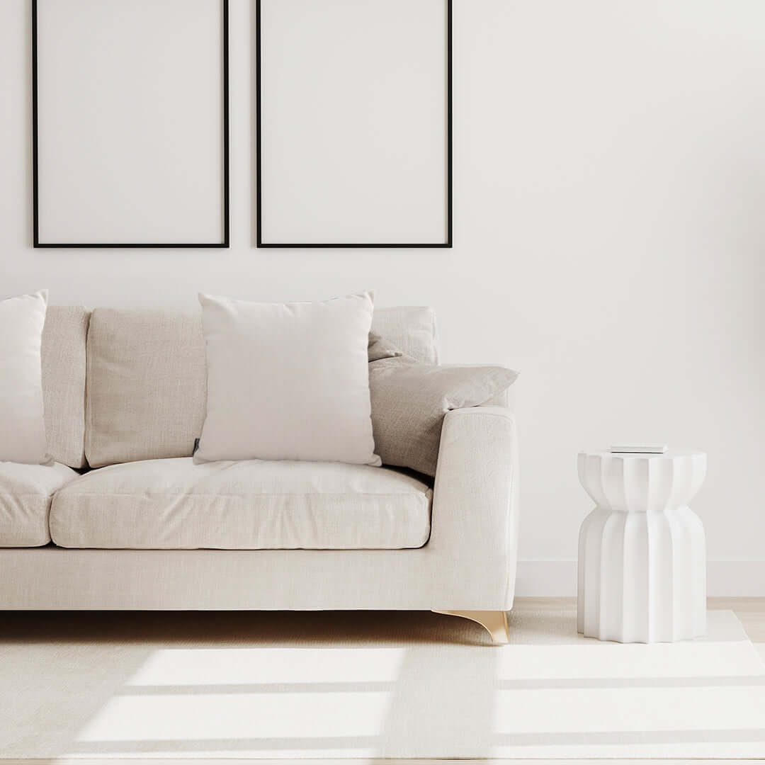 Modern beige sofa with white pillows and chic white side table in a minimalist living room, highlighting affordable, quality homewares and value furniture.