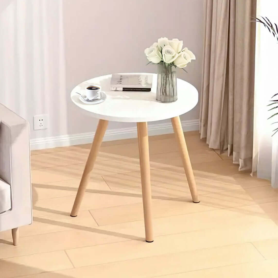 Affordable quality round white table with wooden legs, vase, book, and coffee cup, showcasing value furniture for homewares.