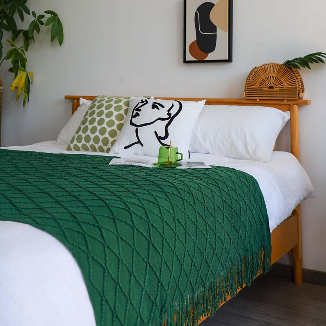 Stylish bedroom with affordable quality homewares including green throw, decorative pillows, and value furniture for a cozy space.