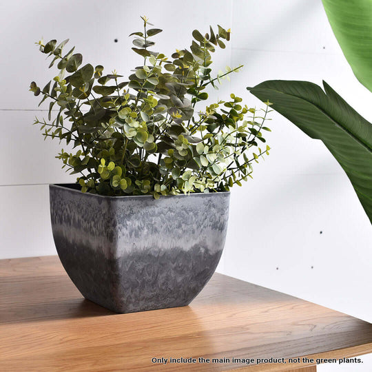 Modern black marble homewares plant pot on wooden table, emphasizing quality and value furniture, with eucalyptus plant inside.