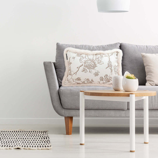 Modern living room with a grey sofa, floral cushion, and wooden coffee table showcasing affordable quality homewares and value furniture.