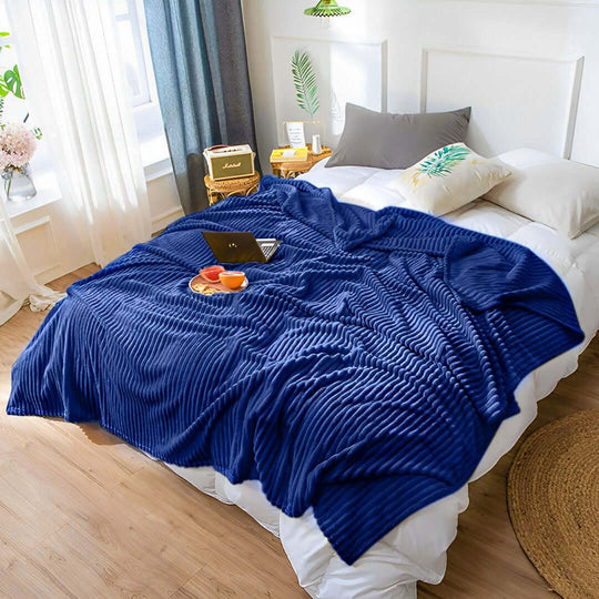 Affordable blue ribbed blanket on a bed with quality pillows and value furniture in a cozy home setting.