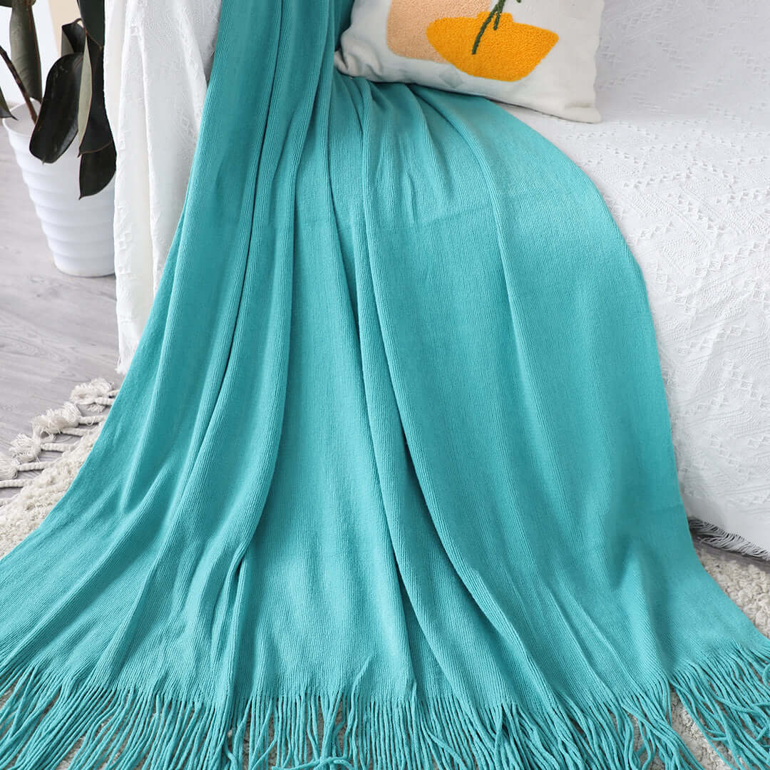 Affordable quality turquoise throw blanket on a bed, highlighting homewares and value furniture.