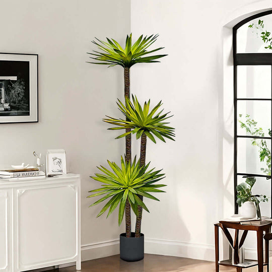 Sleek and modern home interior featuring a tall, vibrant green indoor potted plant, white sideboard, and window letting in natural light.