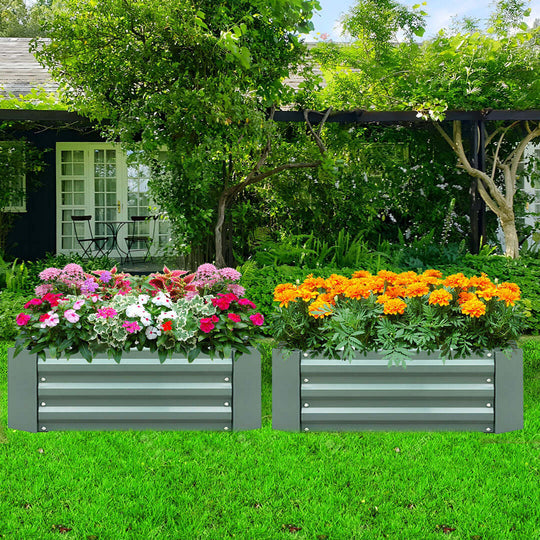 Raised garden beds with colorful flowers in a lush green backyard.