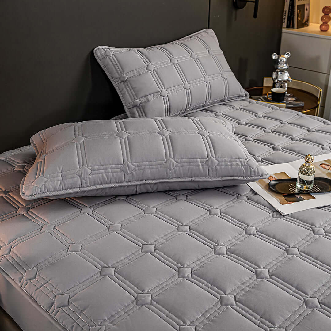 Grey quilted bedding set on bed with matching pillows showcasing affordable, quality homewares and value furniture.