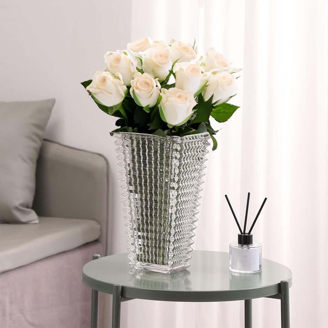 Elegant affordable homeware display featuring quality white roses in a textured vase atop a value furniture table.