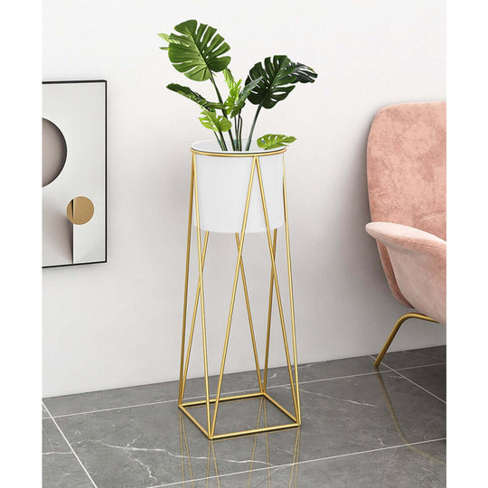 Stylish gold metal plant stand with potted green plant, placed on glossy tile floor next to a pink armchair. Affordable homewares, value furniture.