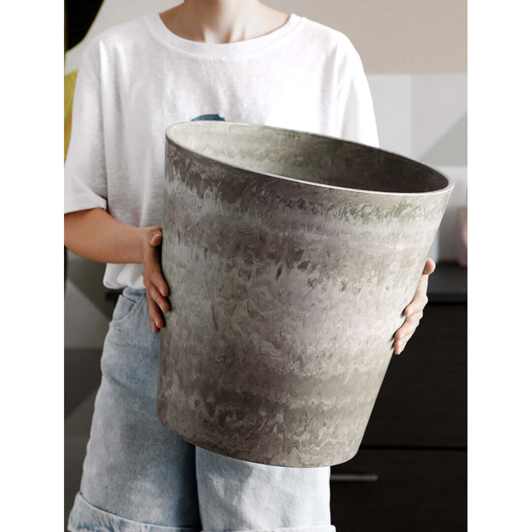 Person holding a large textured ceramic pot showcasing affordable homewares and quality value furniture.