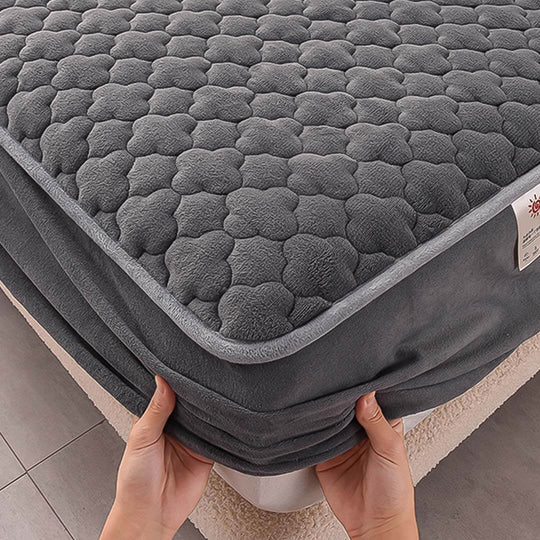 Affordable quality mattress pad with soft textured surface being placed on a bed for added comfort and value furniture.