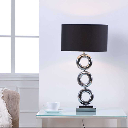 Modern table lamp with black shade on glass table next to window and white cup, showcasing affordable homewares and quality value furniture.