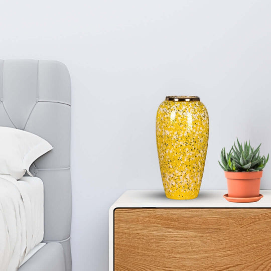 Affordable quality homewares - Stylish yellow vase and green plant on a bedside table with gray upholstered headboard. Value furniture.